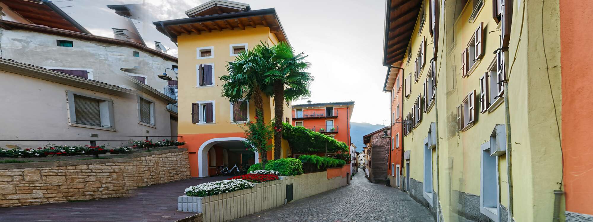 Wer vom Dorf aus zum Schloss Arco spaziert, bahnt sich seinen Weg vom Stadtzentrum mit seinen pittoresken Häuserfassaden durch gepflasterte Gassen, die immer enger werden - Arco in der Region Gardasee